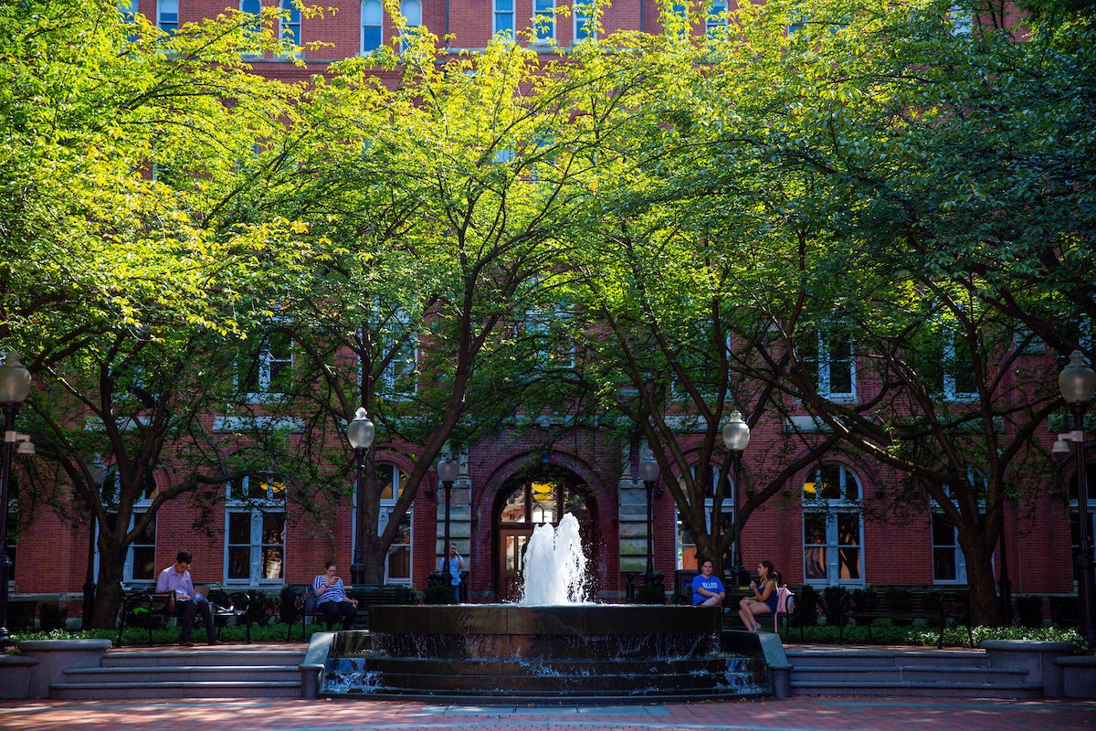 Healy hall fountain with students sitting on the fountain
